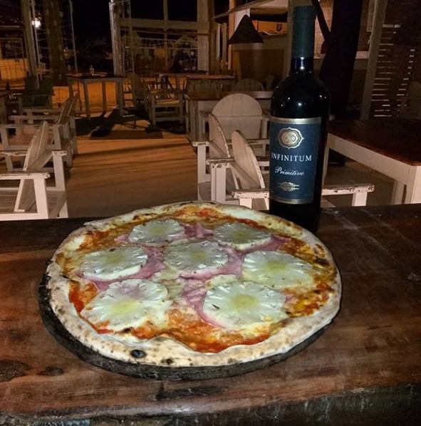 Foto de pizza, vinho e ambiente do Restaurante Cantinetta em Trancoso